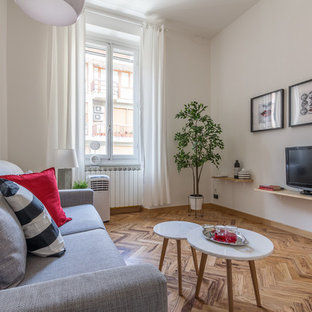 Immagine di un soggiorno design con pareti bianche, pavimento in legno massello medio, TV autoportante e pavimento marrone