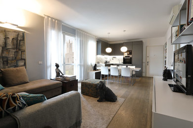Esempio di un soggiorno contemporaneo di medie dimensioni e aperto con pareti grigie, parquet chiaro, parete attrezzata e pavimento grigio