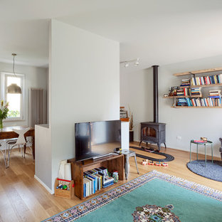 Foto di un soggiorno boho chic con pareti grigie, parquet chiaro, stufa a legna, cornice del camino in metallo, TV autoportante e pavimento beige