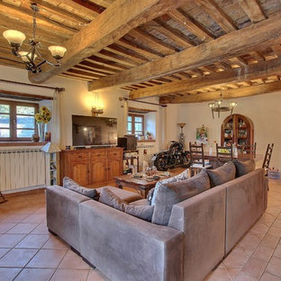 Foto di un soggiorno stile rurale con pareti beige, pavimento in terracotta, TV autoportante e pavimento rosso