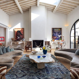 Foto di un soggiorno mediterraneo aperto con pareti bianche, parquet chiaro, camino classico, pavimento beige e soffitto a volta