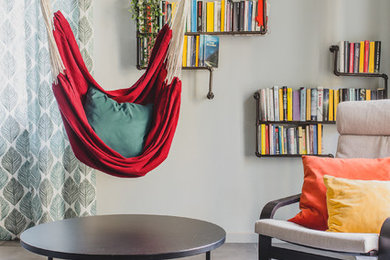 Foto di un soggiorno contemporaneo aperto con libreria, pareti grigie e pavimento grigio