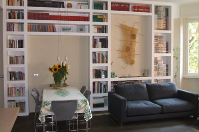 Foto di un soggiorno minimal di medie dimensioni e aperto con libreria, pareti beige, parquet scuro e pavimento marrone
