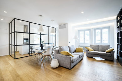 Mittelgroßes, Repräsentatives, Offenes, Fernseherloses Modernes Wohnzimmer ohne Kamin mit weißer Wandfarbe, braunem Holzboden und braunem Boden in Rom