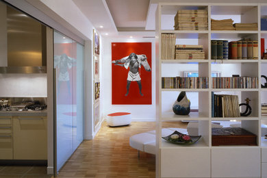 Esempio di un ampio soggiorno design chiuso con libreria, pareti bianche, parquet chiaro, TV a parete, pavimento beige e soffitto ribassato