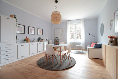 Idee per un soggiorno scandinavo di medie dimensioni e aperto con pareti grigie e parquet chiaro