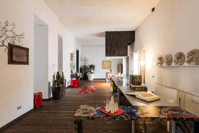 Idee per un soggiorno minimalista stile loft con libreria, pareti bianche e parquet scuro