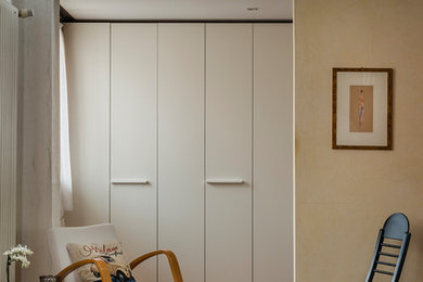 Immagine di un soggiorno minimal stile loft con pareti beige, pavimento marrone e pavimento in legno verniciato