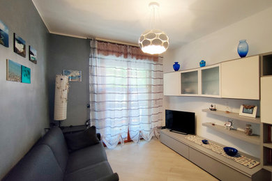 Ejemplo de salón para visitas cerrado mediterráneo de tamaño medio con paredes grises, suelo de baldosas de cerámica, suelo beige y televisor independiente