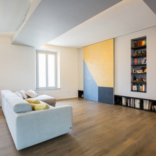 Foto di un soggiorno design aperto con libreria, pareti bianche e pavimento in legno massello medio