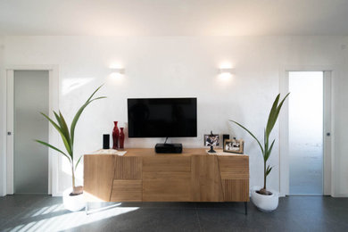 Esempio di un soggiorno minimalista con pareti bianche, pavimento in gres porcellanato e TV a parete