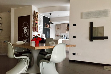 Esempio di una sala da pranzo contemporanea con pareti beige, pavimento in gres porcellanato e cornice del camino in metallo