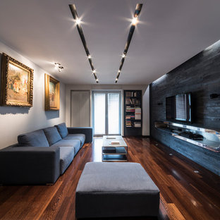Immagine di un piccolo soggiorno contemporaneo chiuso con sala della musica, pavimento in legno massello medio, TV a parete, pareti nere e pavimento marrone