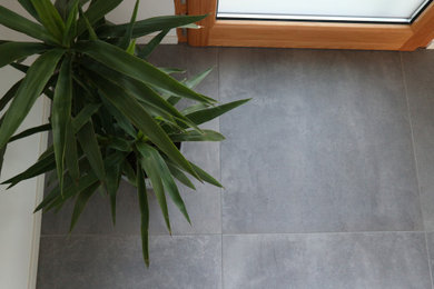 Esempio di un soggiorno minimalista di medie dimensioni con pavimento in gres porcellanato e pavimento grigio