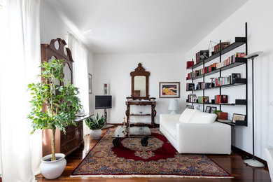 Mittelgroße, Offene Retro Bibliothek mit weißer Wandfarbe, dunklem Holzboden, freistehendem TV und braunem Boden in Florenz