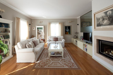 Ispirazione per un grande soggiorno design aperto con camino classico, cornice del camino in pietra, TV a parete e pavimento marrone