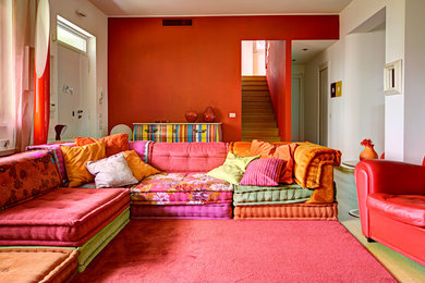 Modelo de sala de estar abierta bohemia de tamaño medio sin chimenea con paredes rojas