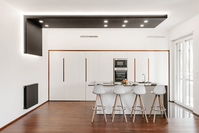 Esempio di un soggiorno minimalista di medie dimensioni e aperto con pareti bianche e pavimento in legno massello medio