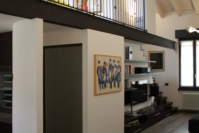 Diseño de salón tipo loft actual grande con paredes blancas, suelo de madera en tonos medios y televisor independiente