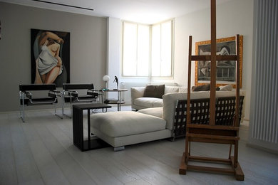 Foto di un soggiorno minimal di medie dimensioni e aperto con pareti beige, parquet chiaro, TV nascosta e pavimento bianco