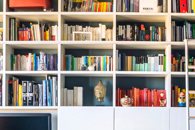 Foto di un soggiorno minimal con libreria, pareti blu, parete attrezzata e pavimento bianco