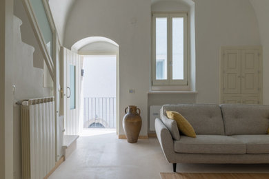 Esempio di un soggiorno design stile loft con pareti beige, pavimento in pietra calcarea, parete attrezzata e pavimento beige