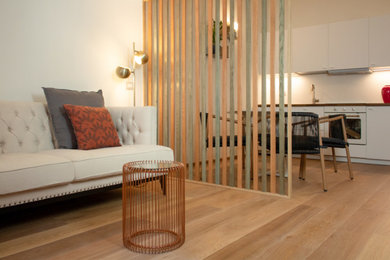 Immagine di un piccolo soggiorno contemporaneo stile loft con pareti bianche, parquet chiaro, TV a parete e carta da parati