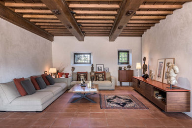 Foto di un soggiorno mediterraneo aperto con pareti bianche, pavimento in terracotta, nessun camino, nessuna TV, pavimento arancione e travi a vista