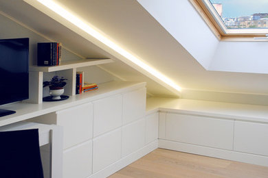 Foto di un piccolo soggiorno minimal stile loft con libreria, pareti bianche, pavimento in legno massello medio, TV autoportante e pavimento beige