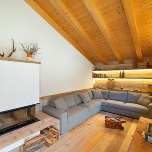 Immagine di un soggiorno stile rurale chiuso con pareti bianche, parquet chiaro, camino bifacciale, nessuna TV, travi a vista, soffitto in legno e soffitto a volta