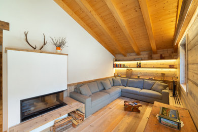 Immagine di un soggiorno stile rurale chiuso con pareti bianche, parquet chiaro, camino bifacciale, nessuna TV, travi a vista, soffitto in legno e soffitto a volta