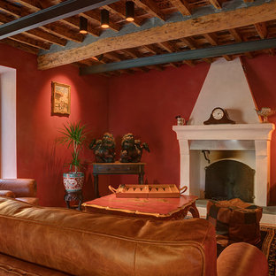 Esempio di un soggiorno mediterraneo con sala formale, pareti rosse, camino classico e travi a vista