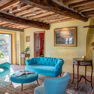 Ispirazione per un soggiorno mediterraneo con sala formale, pareti gialle, pavimento in terracotta, pavimento arancione e travi a vista