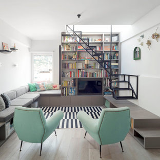 Ispirazione per un soggiorno design con libreria, pareti bianche, parquet chiaro, nessun camino e parete attrezzata