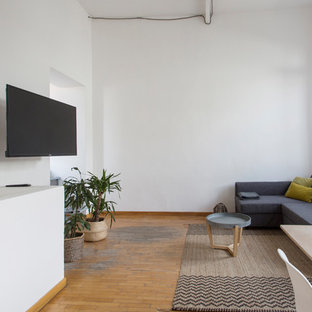 Ispirazione per un grande soggiorno nordico aperto con pareti bianche, pavimento in legno massello medio, nessun camino, pavimento beige e TV a parete
