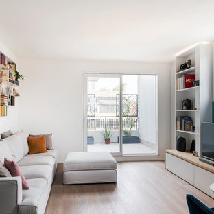 Ispirazione per un soggiorno design di medie dimensioni e aperto con libreria, pareti blu, pavimento in legno massello medio, TV autoportante e pavimento marrone