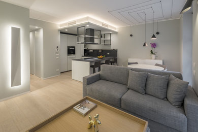 Immagine di un soggiorno moderno di medie dimensioni e aperto con pareti grigie, parquet chiaro, nessun camino, TV nascosta e pavimento giallo