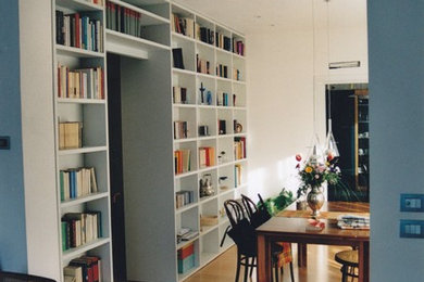 Esempio di un grande soggiorno minimal aperto con libreria, pareti grigie e pavimento in legno massello medio