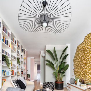 Immagine di un grande soggiorno scandinavo chiuso con libreria, pareti multicolore, parquet chiaro e pavimento beige