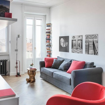 Particolare zona living arredata in grigio e rosso. Parquet in massello di rover