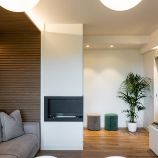 Mittelgroßes, Repräsentatives, Abgetrenntes Modernes Wohnzimmer mit weißer Wandfarbe, Porzellan-Bodenfliesen, Kamin, Kaminumrandung aus Metall, Multimediawand, braunem Boden, Holzdielendecke und vertäfelten Wänden in Mailand