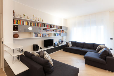 Foto di un grande soggiorno minimal aperto con libreria, pareti bianche, parquet chiaro e TV autoportante