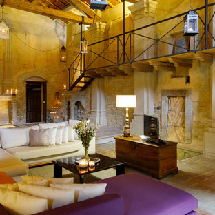 Immagine di un soggiorno country aperto con libreria, pareti beige, TV autoportante e pavimento beige