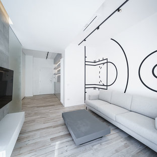 Esempio di un soggiorno minimalista con pareti multicolore, parquet chiaro, nessun camino e TV a parete