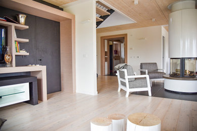 Esempio di un grande soggiorno moderno aperto con libreria, pareti bianche, pavimento in legno massello medio, stufa a legna, parete attrezzata e pavimento beige