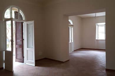 Idee per un grande soggiorno chic con pareti beige, pavimento in terracotta e pavimento marrone