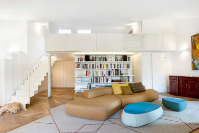 Immagine di un ampio soggiorno contemporaneo aperto con libreria, pareti bianche e parquet chiaro