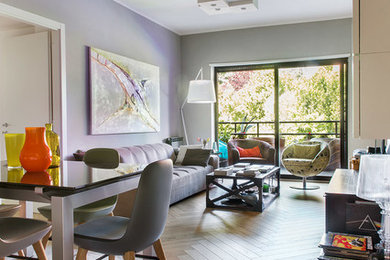 Immagine di un soggiorno design di medie dimensioni e chiuso con pareti grigie, parquet chiaro, parete attrezzata e pavimento beige