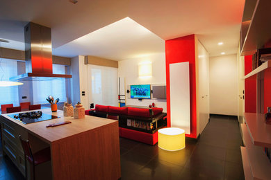 Immagine di un grande soggiorno minimalista aperto con pareti rosse, pavimento in gres porcellanato, TV a parete e pavimento nero