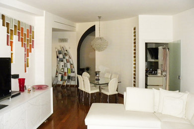 Modelo de salón abierto moderno grande con paredes blancas, suelo de madera en tonos medios, chimenea de esquina, marco de chimenea de piedra, pared multimedia y suelo marrón